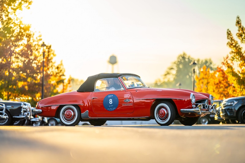 Red vintage Mercedes Benz parked with other cars.